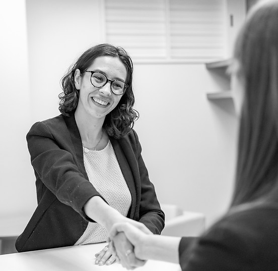 Young Woman in Business Attire Shaking H